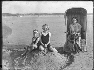 69 Scène van vrouwen in het strand zittende in zand en op strandstoel, ca 1905-1935